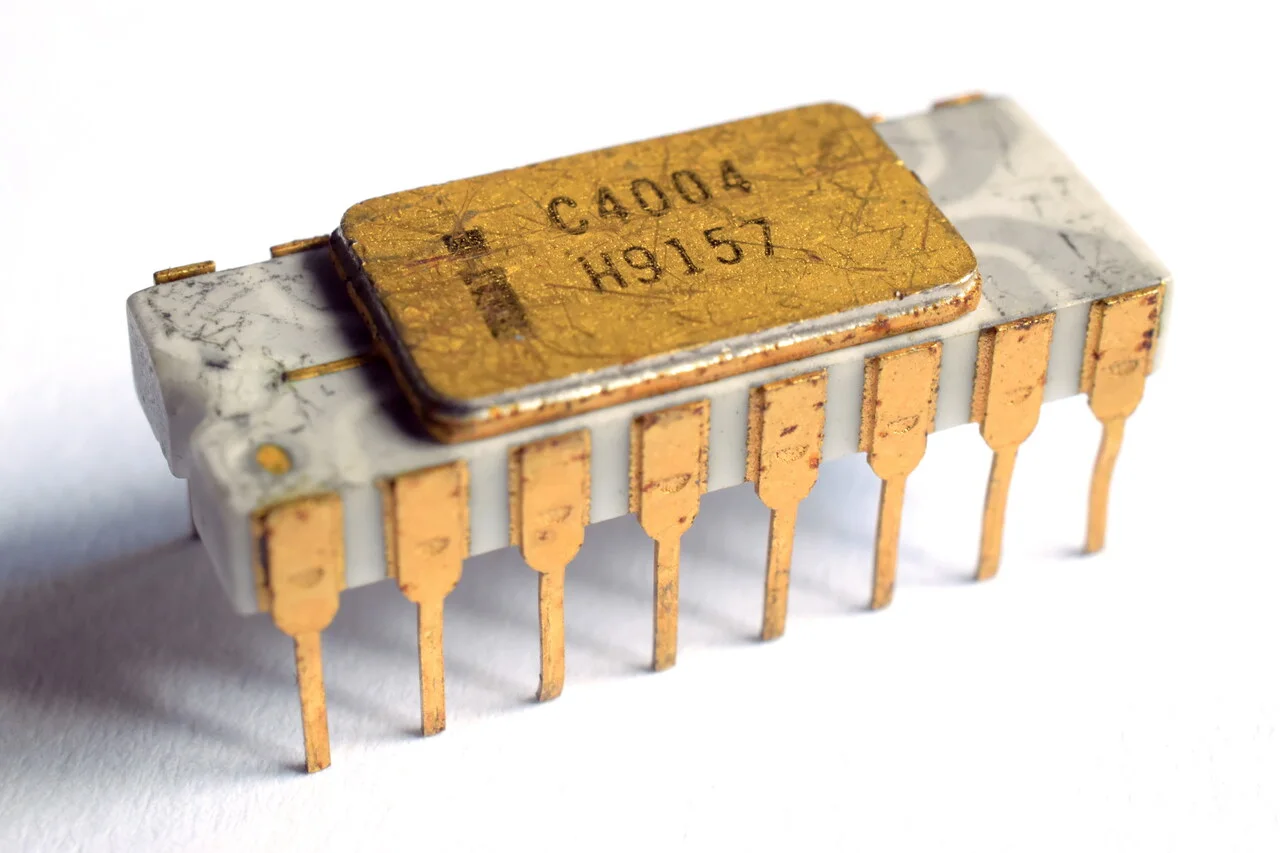 Microprocesador Intel C4004 de 1971, el primer microprocesador comercial, con su encapsulado cerámico blanco y tapa dorada